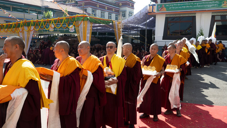 Monjes sosteniendo ofrendas para Su Santidad el Dalái Lama alineados fuera de Sera Lachi durante la Ofrenda de Oraciones de Larga Vida ofrecida por el Monasterio de Sera en Bylakuppé, Karnataka, India, el 5 de febrero de 2025. Foto de Ven Zamling Norbu.