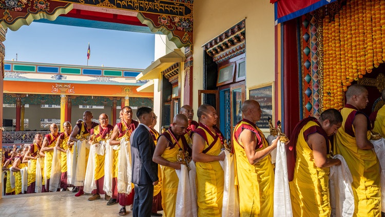 Monks holding offerings for His Holiness the Dalai Lama lined up outside the Main Assembly Hall during the Long Life Prayers at Gyudmed Tantric University in Hunsur, Karnataka, India on February 17, 2025. Photo by Tenzin Choejor