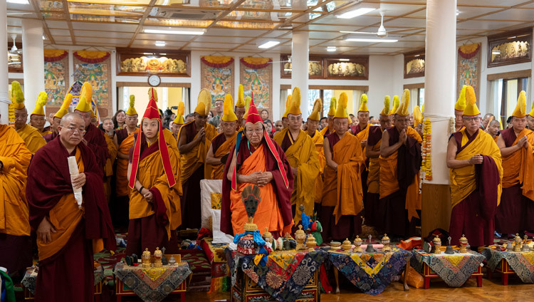 Members of the congregation standing as His Holiness the Dalai Lama arrives to attend Long Life Prayers offered to him by Nechung Monastery at his old residence in Dharamsala, HP, India on March 24, 2025. Photo by Tenzin Choejor